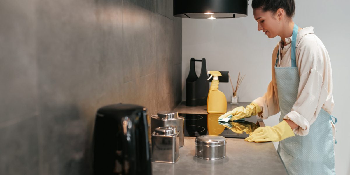 Disinfection. Young dark-haired woman disinfecting the surfaces in the kitchen